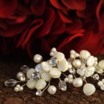 A-5636

4 ½” comb of twisted wires tipped with MOP flowers, freshwater pearls, tri pearls and olive crystals,  with a side accent of 2 MOP flowers with rhinestone centers….(Diamond white freshwater pearl)